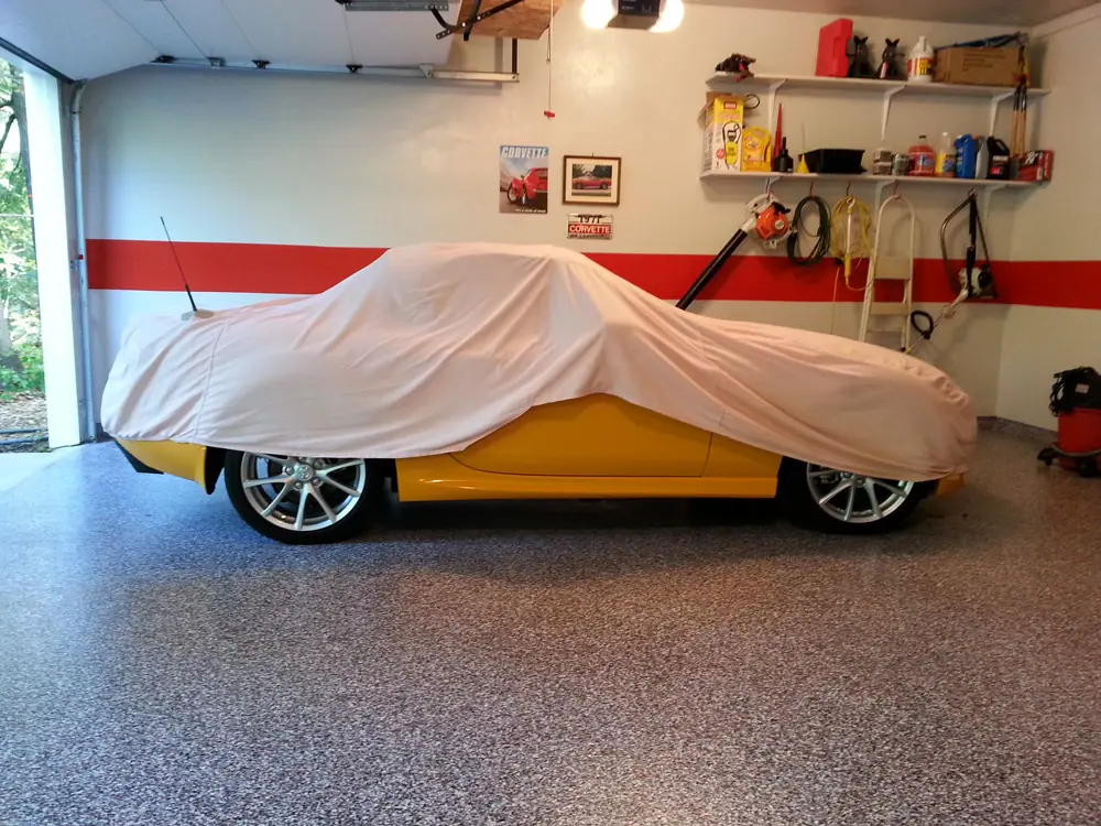 Flake garage floor coating with a covered sports car